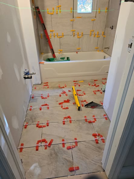 Bathroom during: new floor tile being levelled