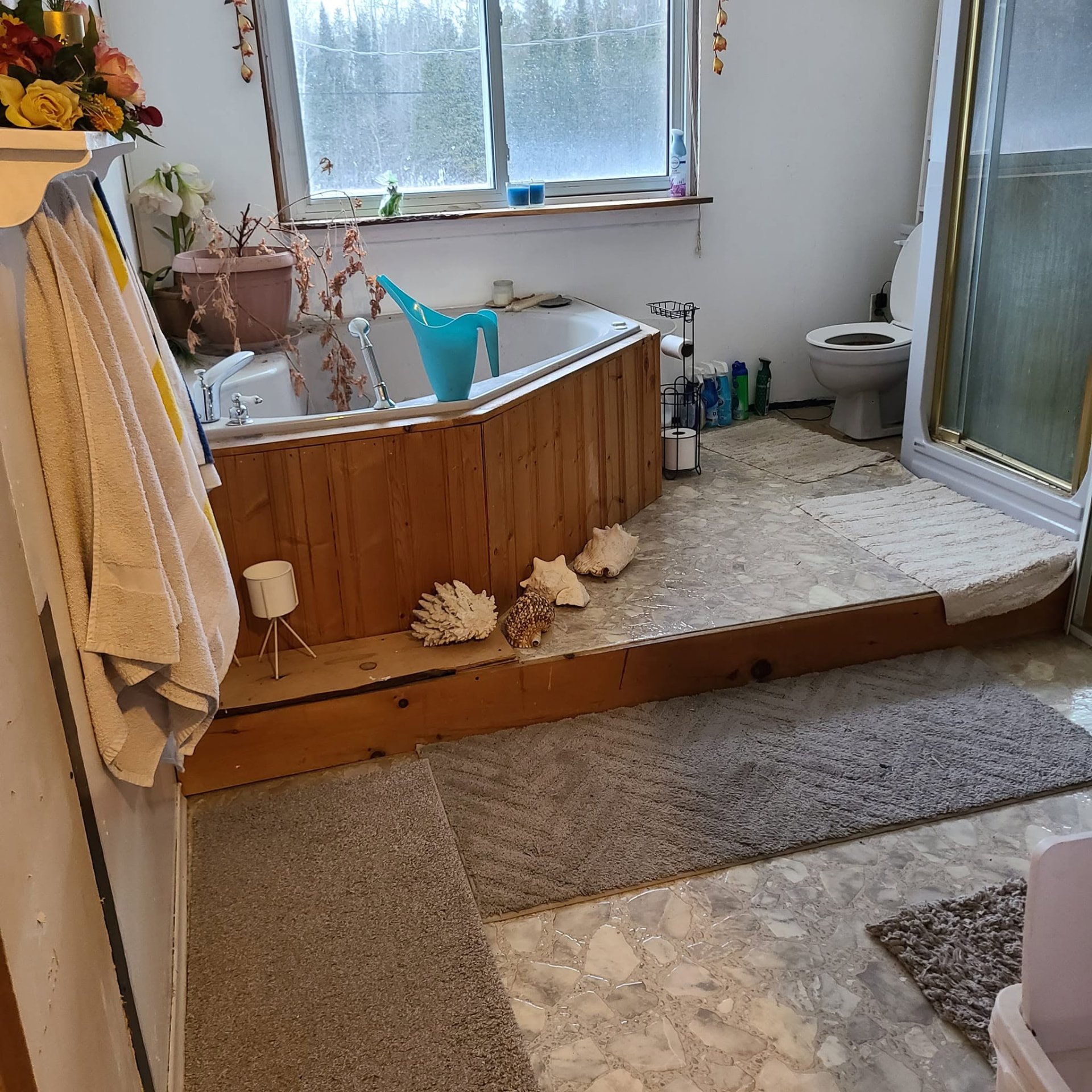 Before: old flooring in a room with a corner tub