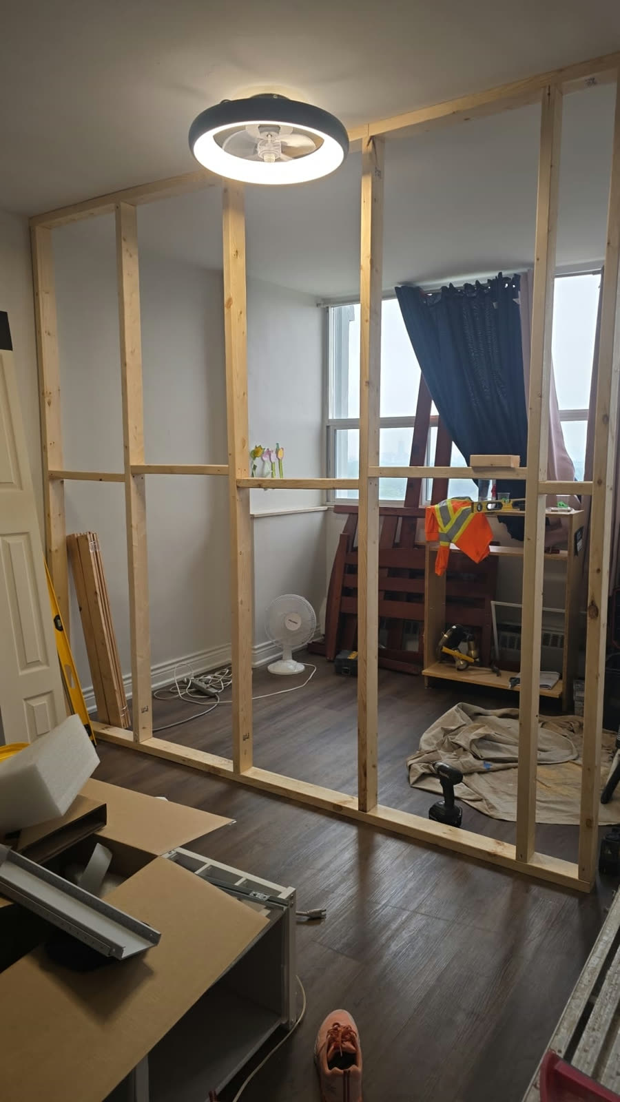 Bedroom before: open room with a new partition wall frame in place