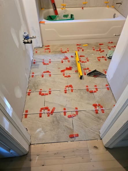 Bathroom floor tile being levelled